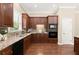 Well-lit kitchen featuring granite countertops, dark wood cabinets, and stainless steel appliances at 1065 Beacon Hill Xing, Alpharetta, GA 30005
