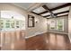 Bright living room with hardwood floors, coffered ceilings, stylish lighting, and large windows offering outdoor views at 1065 Beacon Hill Xing, Alpharetta, GA 30005
