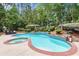 In-ground pool with attached hot tub surrounded by mature landscaping at 1065 Beacon Hill Xing, Alpharetta, GA 30005