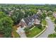 Aerial of home in a manicured neighborhood with tree-lined streets and sidewalks at 2444 Mossy Branch Dr, Snellville, GA 30078