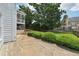 Well-maintained backyard with manicured hedges, a grassy lawn, and a view of the raised porch at 2444 Mossy Branch Dr, Snellville, GA 30078