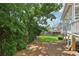 Beautifully landscaped backyard with mature trees and a partial view of the back of the house at 2444 Mossy Branch Dr, Snellville, GA 30078