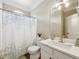 Well-lit bathroom featuring a vanity with a sink, mirror, and a shower with a decorative curtain at 2444 Mossy Branch Dr, Snellville, GA 30078