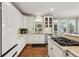 Bright kitchen featuring white cabinetry, granite countertops, and stainless steel appliances and hardwood floors at 2444 Mossy Branch Dr, Snellville, GA 30078