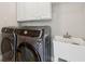 Laundry room with stainless steel washer and dryer and utility sink at 2444 Mossy Branch Dr, Snellville, GA 30078