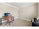 Well-lit home office with neutral walls, carpeted floor, and a modern desk and keyboard setup at 2444 Mossy Branch Dr, Snellville, GA 30078