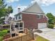 View of the rear exterior with a covered porch and attached two-car garage at 2444 Mossy Branch Dr, Snellville, GA 30078