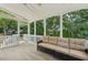Relaxing screened porch featuring a plush sofa and serene views of the lush backyard at 2444 Mossy Branch Dr, Snellville, GA 30078