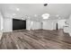 Bright living room featuring a modern light fixture, accent wall and luxury vinyl flooring at 1978 Ethel Ln, Decatur, GA 30032