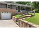 Stone steps lead up to this home with brick and siding, attached garage, and green lawn at 3105 Sumac Dr, Atlanta, GA 30360