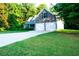 Exterior facade featuring stone accents, two-car garage, driveway, and lush, green lawn at 85 Lamar Ln, Covington, GA 30016