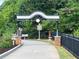 Inviting entrance to a greenway trail, featuring decorative archway, brick pillars, and a paved pathway at 4876 Velva Nw Way, Lilburn, GA 30047
