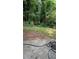 Overgrown backyard, framed by trees, offering a calm canvas for outdoor enjoyment and creative landscaping ideas at 1009 Autumn Crest Ct, Stone Mountain, GA 30083