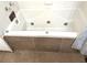 Jetted bathtub with brown tile surround and silver fixtures at 1041 Waverly Drive Dr, Lawrenceville, GA 30046