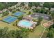 Aerial view of community amenities featuring a pool, clubhouse, tennis courts, playground, and ample parking at 1170 Shellnut Trl, Hoschton, GA 30548