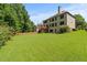 Expansive backyard with a lush lawn, wooden fence, mature trees, and rear view of the house at 1170 Shellnut Trl, Hoschton, GA 30548