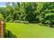 A spacious, well-maintained backyard with lush green grass and mature trees offers privacy and space for recreation at 1170 Shellnut Trl, Hoschton, GA 30548