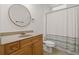 Bathroom featuring a round mirror, wood vanity, toilet, and shower with curtain at 1170 Shellnut Trl, Hoschton, GA 30548