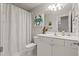 Bright bathroom with modern white vanity, crab art, and shower with patterned curtain at 1170 Shellnut Trl, Hoschton, GA 30548