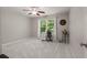 Spacious bedroom with neutral paint, ceiling fan, and large windows overlooking greenery at 1170 Shellnut Trl, Hoschton, GA 30548