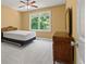 Bright bedroom with ceiling fan, neutral walls, plush carpet, and a wooden dresser at 1170 Shellnut Trl, Hoschton, GA 30548