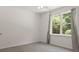 Bright bedroom with natural light streaming through the large window and gray curtains at 1170 Shellnut Trl, Hoschton, GA 30548