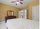 Bedroom with ceiling fan and an antique dresser with a large framed mirror at 1170 Shellnut Trl, Hoschton, GA 30548