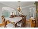 Elegant dining room with hardwood floors, decorative chandelier, and access to a living room at 1170 Shellnut Trl, Hoschton, GA 30548