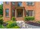 Home's front door, with brick stairs and decorative greenery, is framed by classic architectural columns at 1170 Shellnut Trl, Hoschton, GA 30548