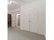 Carpeted hallway area with a closet and door to another room with shelving at 1170 Shellnut Trl, Hoschton, GA 30548