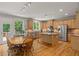 Open kitchen features granite countertops, stainless appliances, light wood cabinets and eat-in breakfast area at 1170 Shellnut Trl, Hoschton, GA 30548