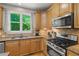 Kitchen features stainless steel appliances, granite countertops, wood cabinets, and a window with natural light at 1170 Shellnut Trl, Hoschton, GA 30548