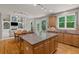 Open kitchen features a central island, wood cabinets, and a dining area with views into the adjacent living area at 1170 Shellnut Trl, Hoschton, GA 30548