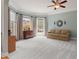 Bright living room with plush carpeting, large windows with curtains, and neutral wall color at 1170 Shellnut Trl, Hoschton, GA 30548
