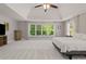 Spacious main bedroom with tray ceiling, neutral carpet, large windows overlooking nature at 1170 Shellnut Trl, Hoschton, GA 30548