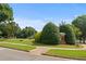Autumn Park entrance features landscaped shrubs, grassy area, and sidewalks on a sunny day at 1170 Shellnut Trl, Hoschton, GA 30548