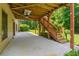 Covered patio area with a ceiling fan and stairs leading to an upper deck, ideal for outdoor relaxation at 1170 Shellnut Trl, Hoschton, GA 30548
