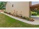 Side view showcasing the home's foundation, with planters, garden, and a pathway leading to the backyard at 1170 Shellnut Trl, Hoschton, GA 30548