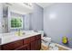 Bathroom with a single sink vanity, toilet, mirror and a bright window at 3832 Augustine Pl, Rex, GA 30273