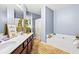 Bright bathroom featuring tile floors, double vanity, and a soaking tub at 3832 Augustine Pl, Rex, GA 30273