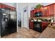 Kitchen featuring stainless steel refrigerator, dark cabinets, tile backsplash and black oven at 3832 Augustine Pl, Rex, GA 30273