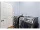 Modern laundry room featuring gray washer and dryer next to a white door at 3832 Augustine Pl, Rex, GA 30273