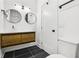 Modern bathroom featuring dual circular mirrors, sleek wood vanity, and stylish black tiled flooring at 1266 Elizabeth Sw Ave, Atlanta, GA 30310