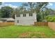 View of home's exterior and spacious fenced backyard with lush lawn; perfect for outdoor enjoyment at 1266 Elizabeth Sw Ave, Atlanta, GA 30310