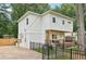 Side view of a modern home featuring a charming porch, well-maintained yard, and a secure black fence at 1266 Elizabeth Sw Ave, Atlanta, GA 30310