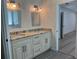 Bathroom featuring granite counters, modern lighting, dual sinks, and gray tile flooring at 455 Crafton Ct, Lawrenceville, GA 30043