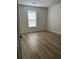 Bedroom featuring wood-look floors, neutral walls, and a bright window at 455 Crafton Ct, Lawrenceville, GA 30043