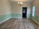 Dining room with crown molding and chair rails, featuring wood-look flooring and modern chandelier at 455 Crafton Ct, Lawrenceville, GA 30043
