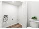 Bright laundry area with modern wood-look floors and easy access to a half bathroom at 197 Holcomb Ferry Rd, Roswell, GA 30076