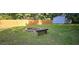 Landscaped backyard featuring a fire pit, bench, and lush green lawn, ideal for outdoor gatherings at 2357 Whitehouse Rd, Dacula, GA 30019